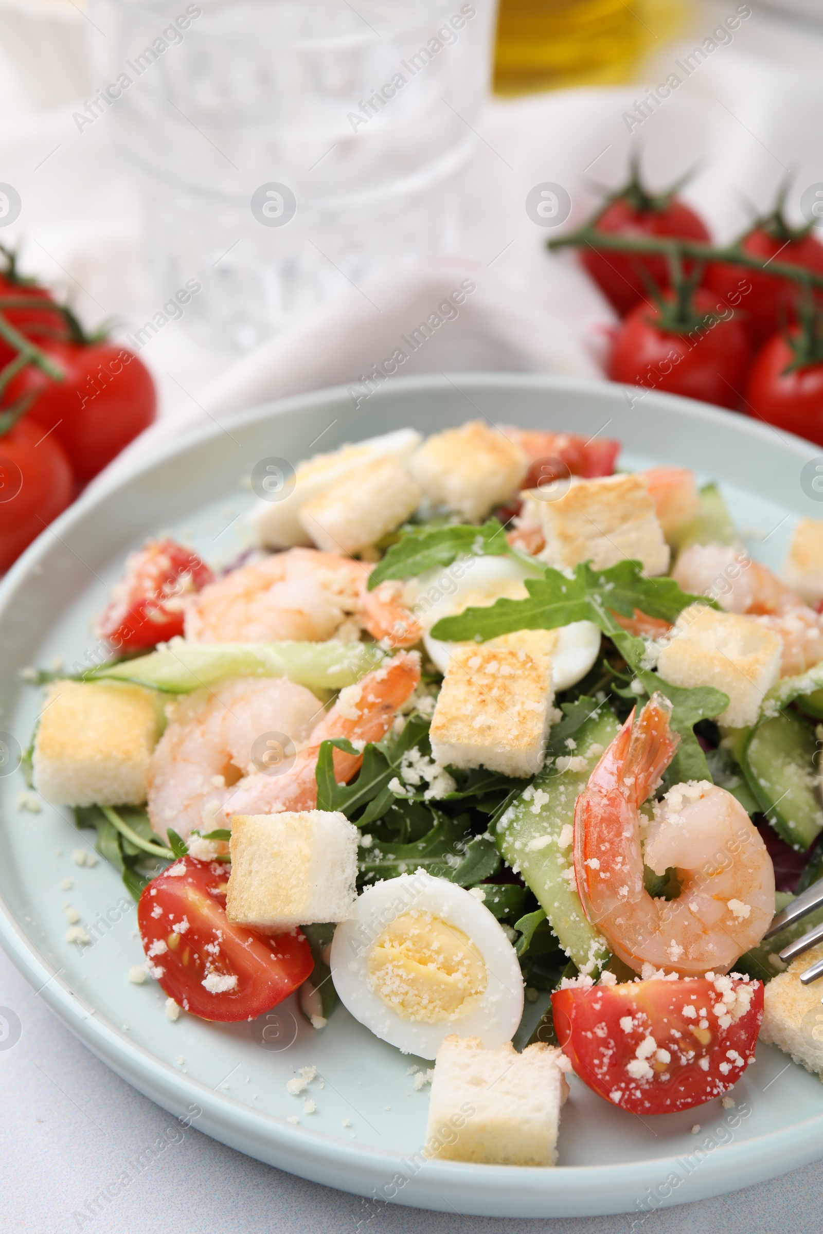 Photo of Delicious Caesar salad with shrimps on white table, closeup