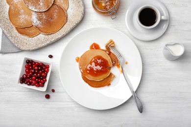 Delicious pancakes with jam served for breakfast on table, top view