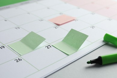 Photo of Timetable. Planner with sticky notes and green felt pen on grey table, closeup