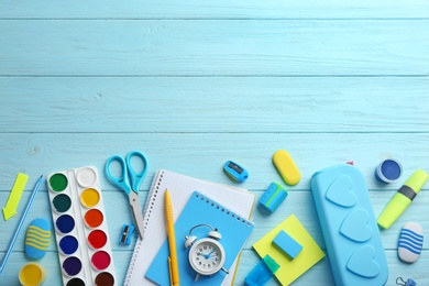 Photo of Different bright school stationery on light blue wooden background, flat lay. Space for text