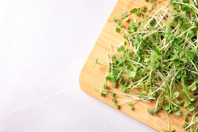 Photo of Fresh organic microgreen on white table, top view. Space for text