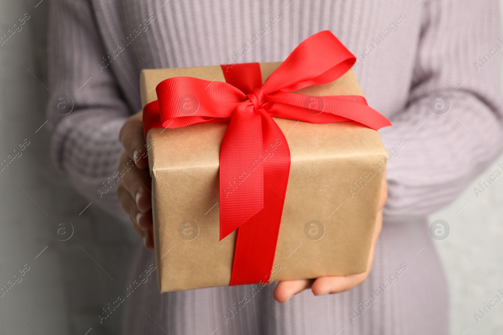 Photo of Young woman holding Christmas gift, closeup view