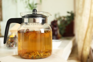 Photo of Freshly brewed herbal tea on table indoors, space for text