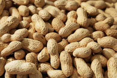 Photo of Many fresh unpeeled peanuts as background, closeup