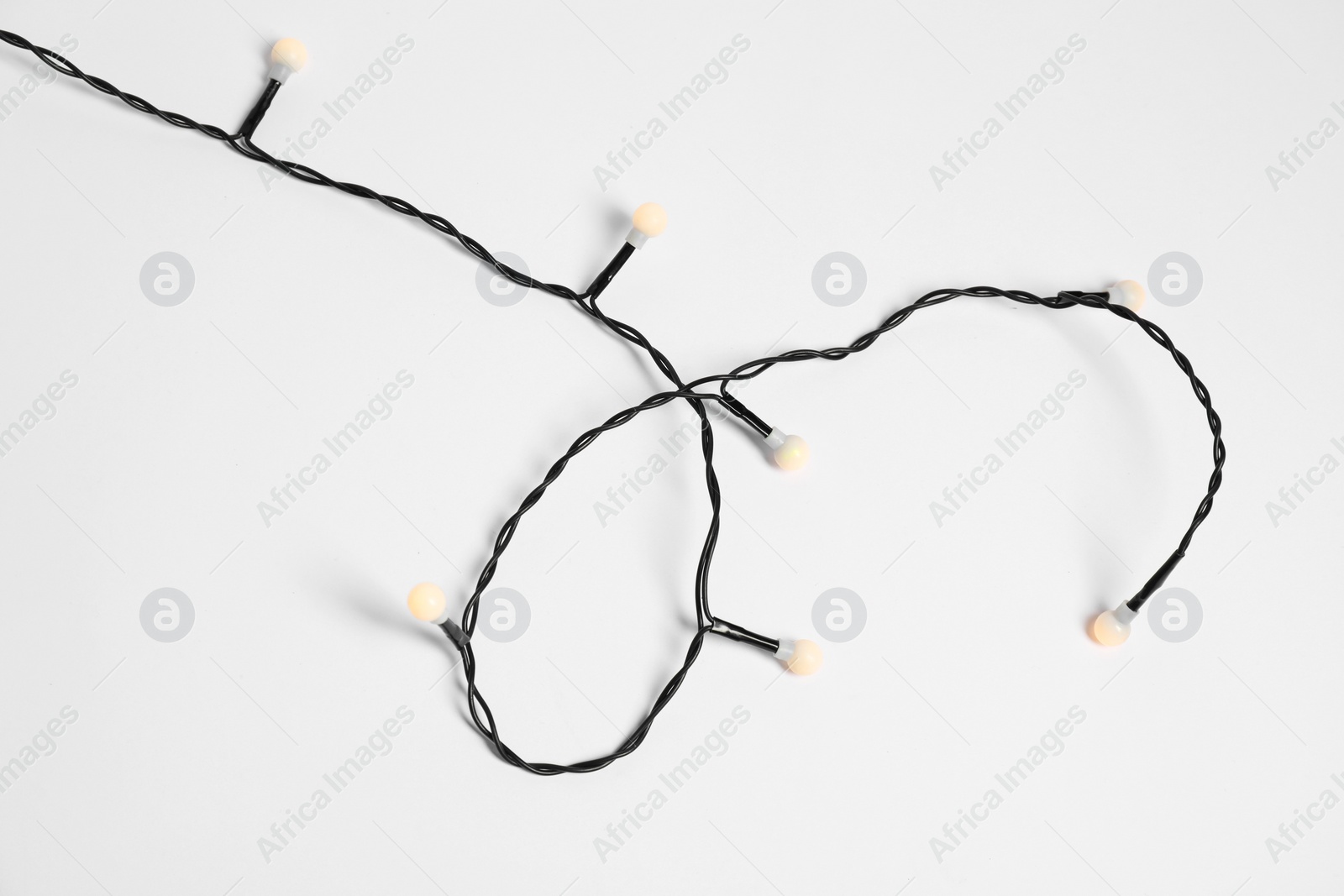 Photo of Beautiful Christmas lights on white background, top view