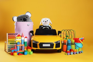 Photo of Child's electric car with other toys on yellow background
