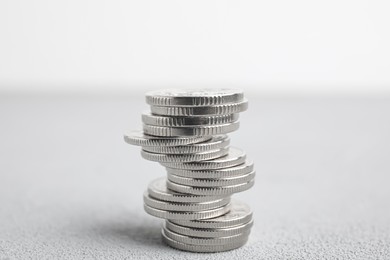 Photo of Many silver coins stacked on white table