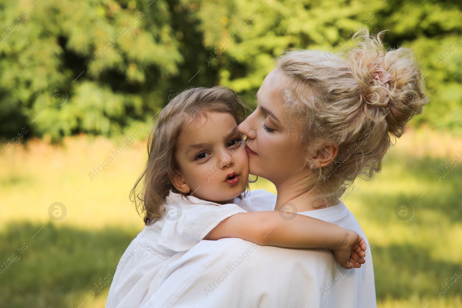 Photo of Beautiful mother with her cute daughter spending time together outdoors