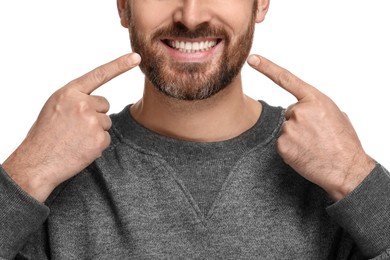 Photo of Smiling man pointing at his healthy clean teeth on white background, closeup