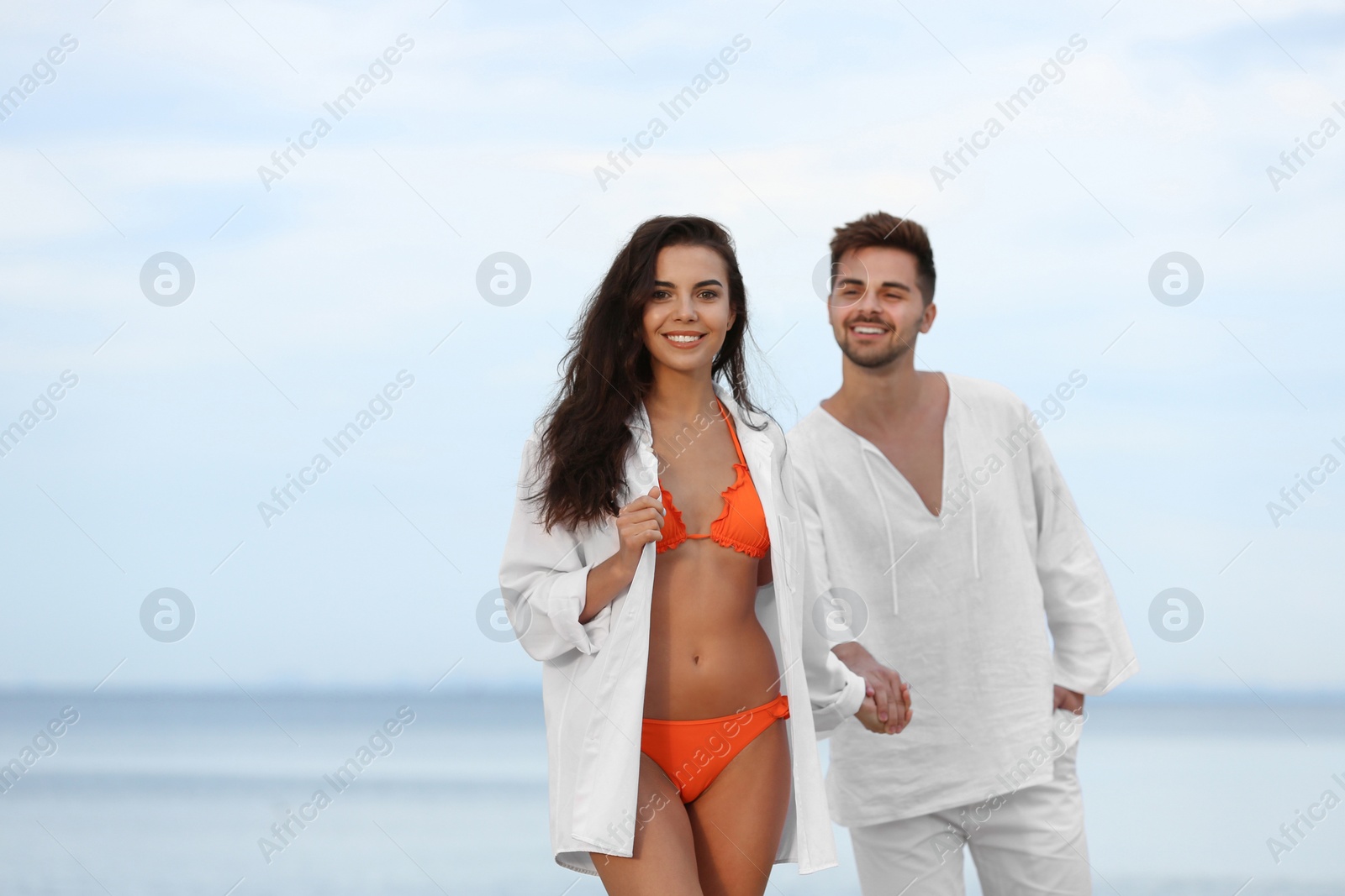 Photo of Happy young couple walking together on beach