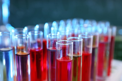 Photo of Test tubes in rack against blurred background, closeup. Chemistry glassware