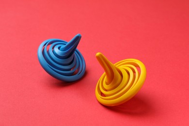 Photo of Blue and yellow colorful spinning tops on red background