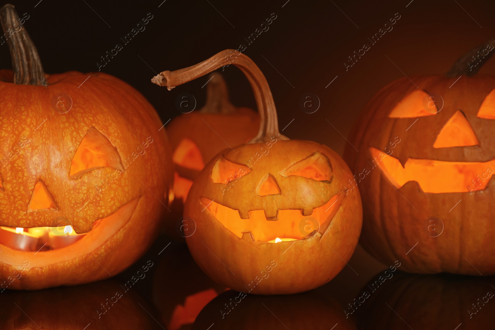 Photo of Halloween pumpkin heads. Glowing jack lanterns in dark