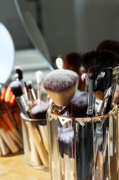 Set of professional brushes on wooden table, closeup