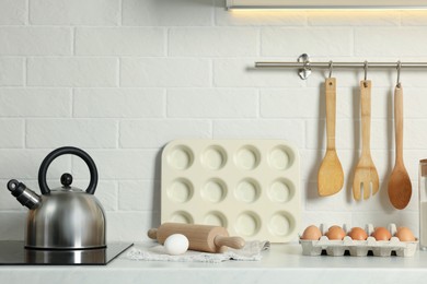 Photo of Countertop with stove, products and cooking utensils in kitchen