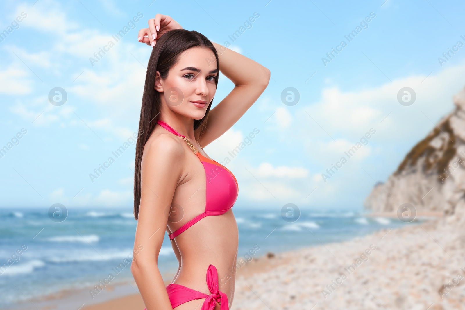 Image of Beautiful woman in stylish pink bikini on sandy beach near sea, space for text