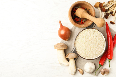 Photo of Flat lay composition with different ingredients on white wooden table, space for text. Risotto recipe