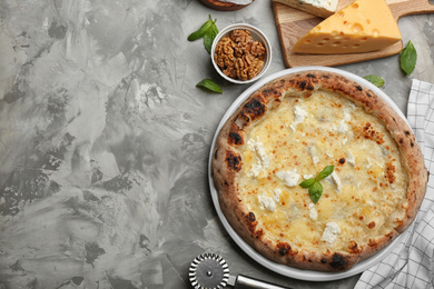 Delicious cheese pizza and fresh ingredients on grey table, flat lay. Space for text