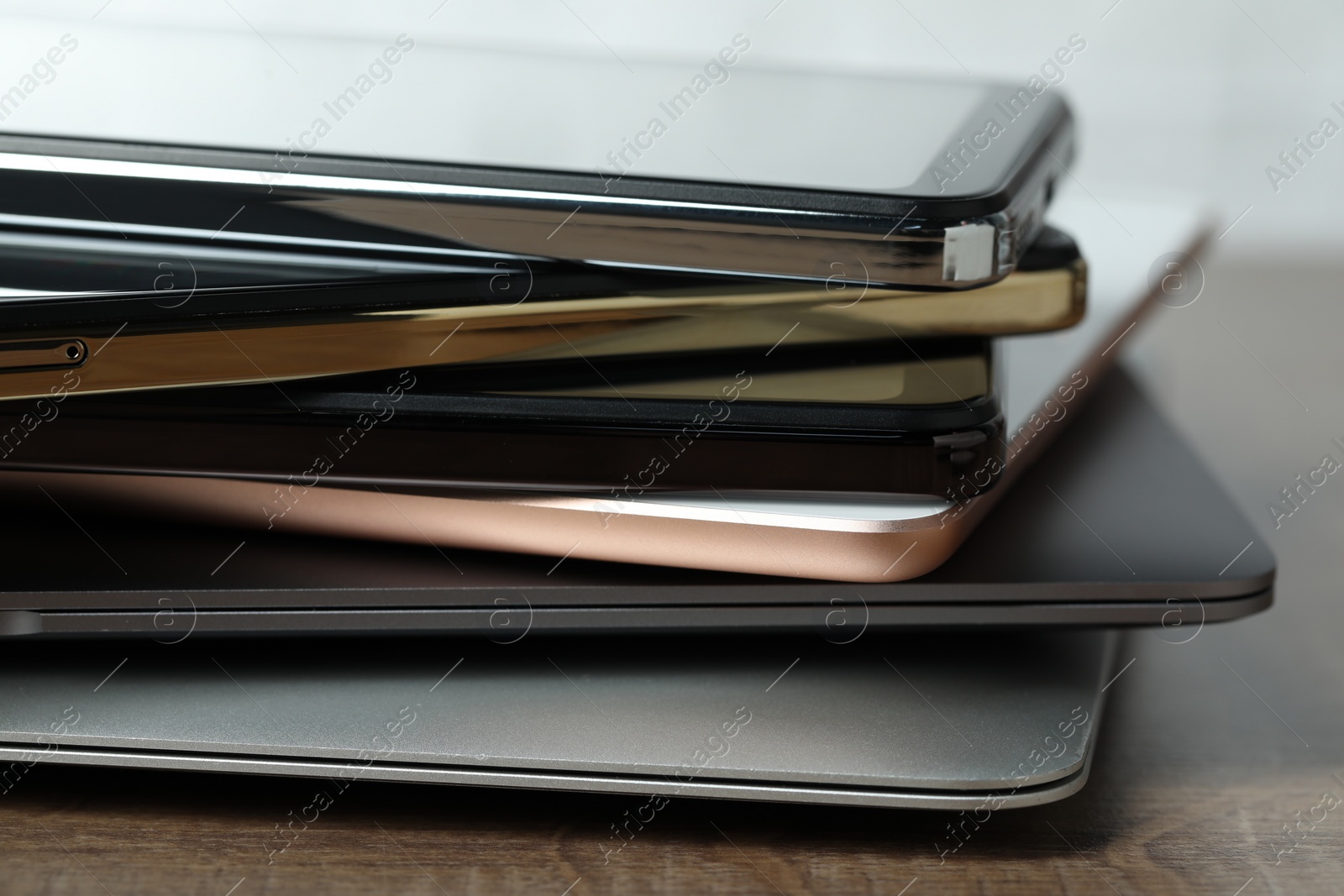 Photo of Stack of electronic devices on wooden table, closeup