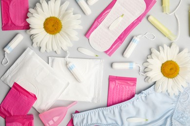 Photo of Tampons and other menstrual hygienic products on grey background, flat lay