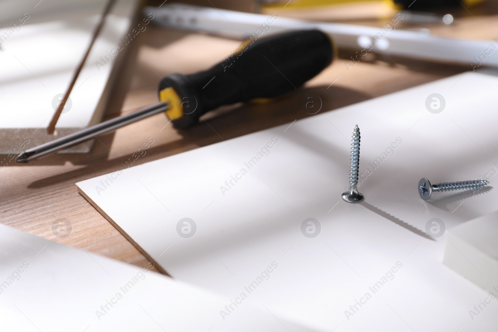 Photo of Furniture parts and equipment for self-assembly on wooden table