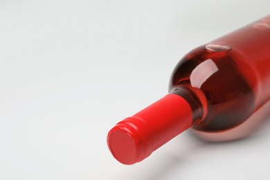 Photo of Bottle of expensive rose wine on light background