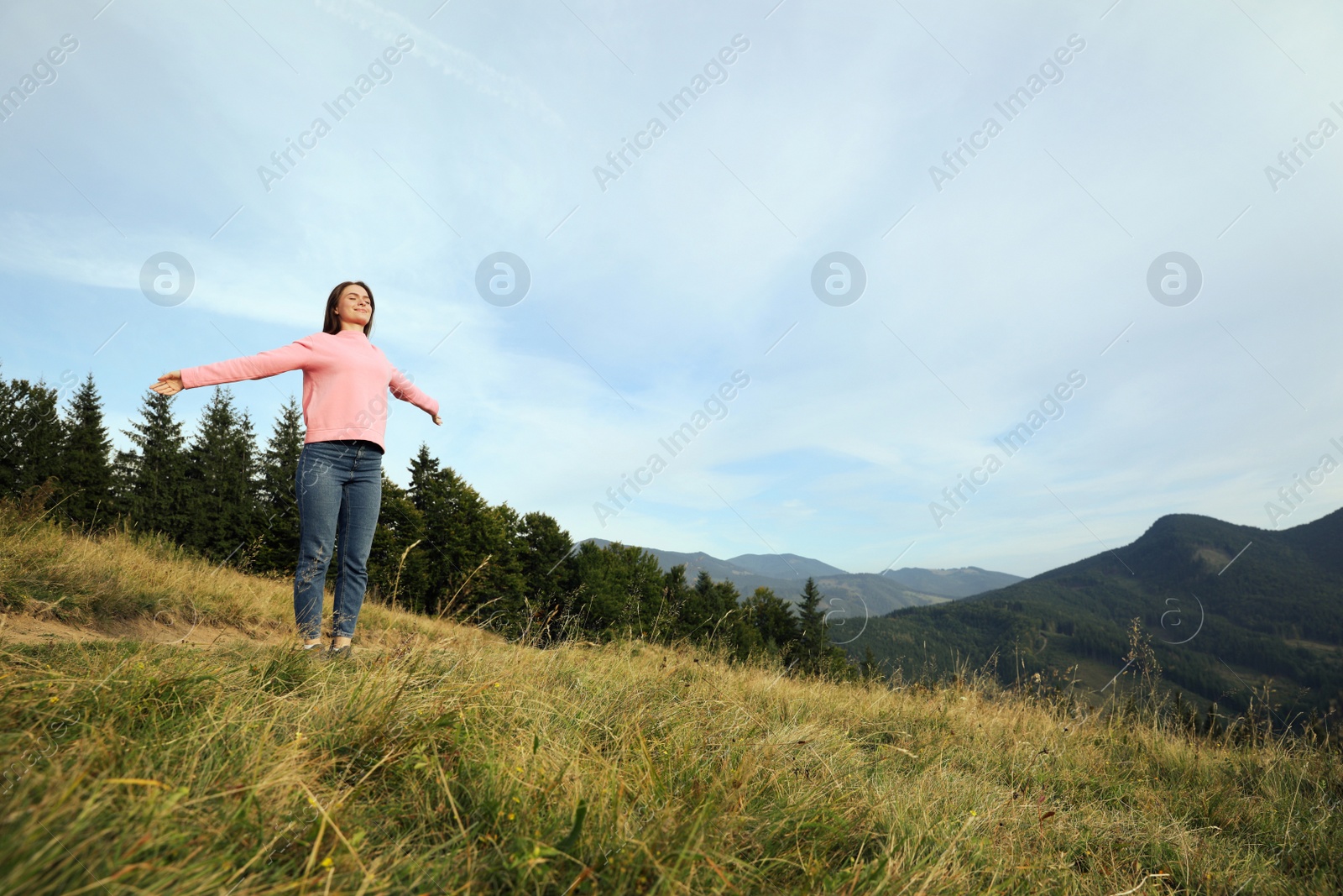 Photo of Young woman enjoying mountain landscape. Space for text