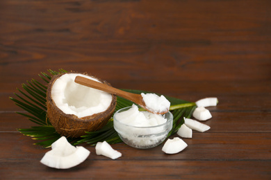 Photo of Composition with organic coconut oil on wooden table. Healthy cooking