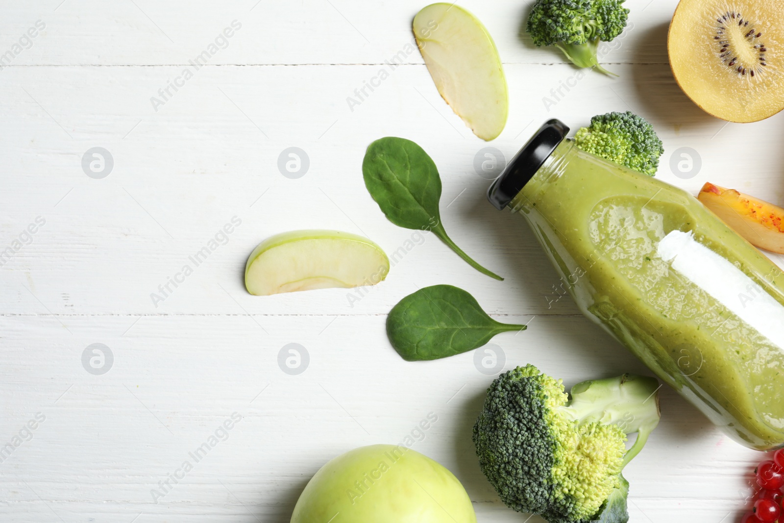 Photo of Bottles of delicious juices and fresh fruits on white wooden table, flat lay