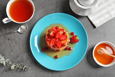 Photo of Flat lay composition with tasty pancakes and tea set on table