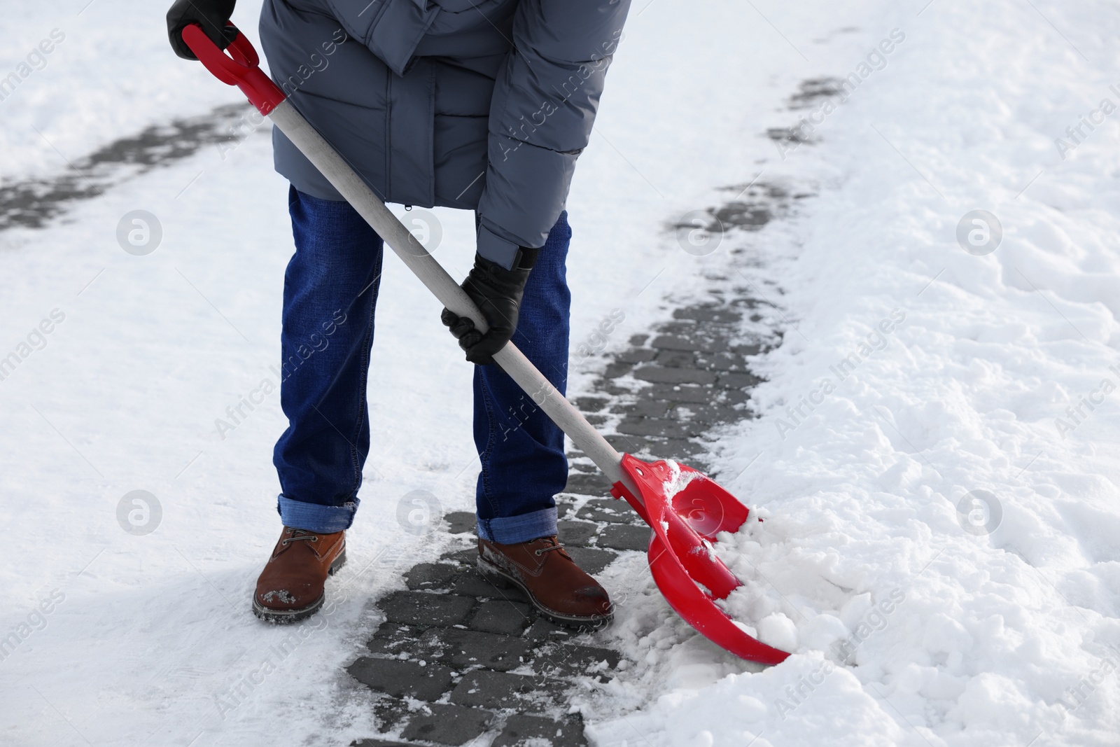 Photo of Man removing snow with shovel outdoors, closeup