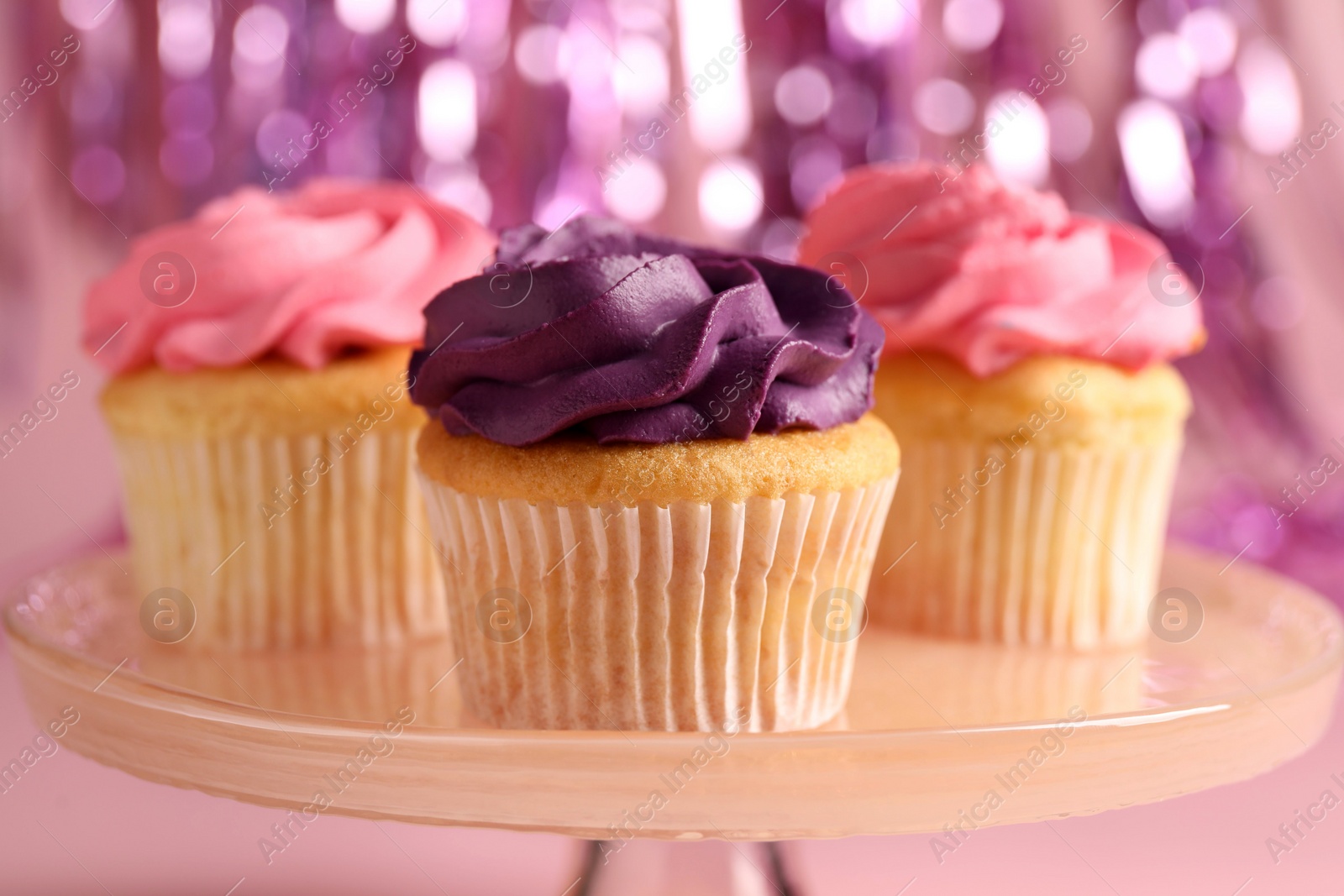 Photo of Delicious cupcakes with bright cream on pink background, closeup