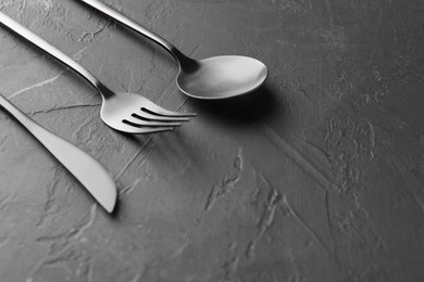 Photo of Beautiful cutlery set on black table, closeup. Space for text