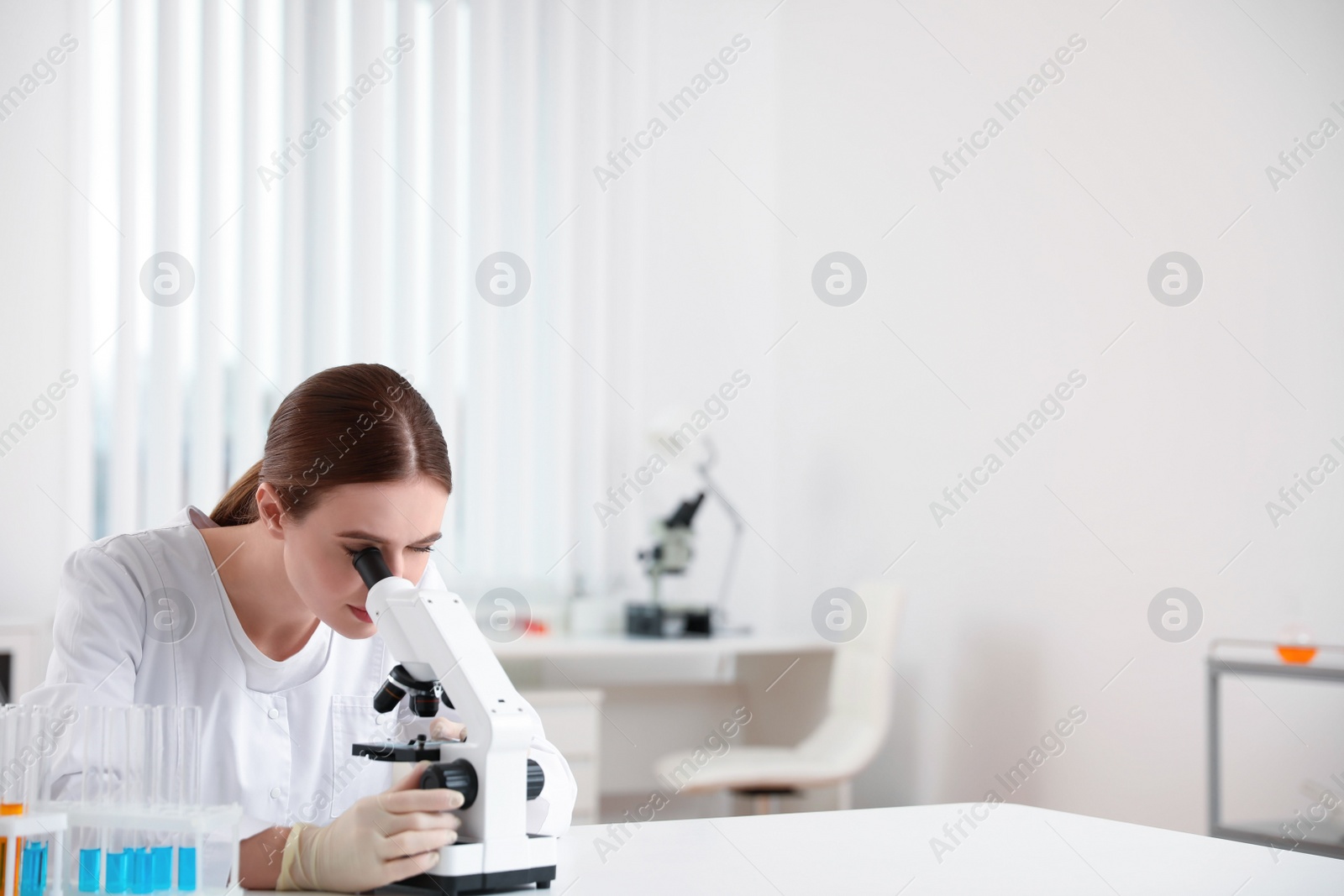 Photo of Scientist using modern microscope at table. Medical research