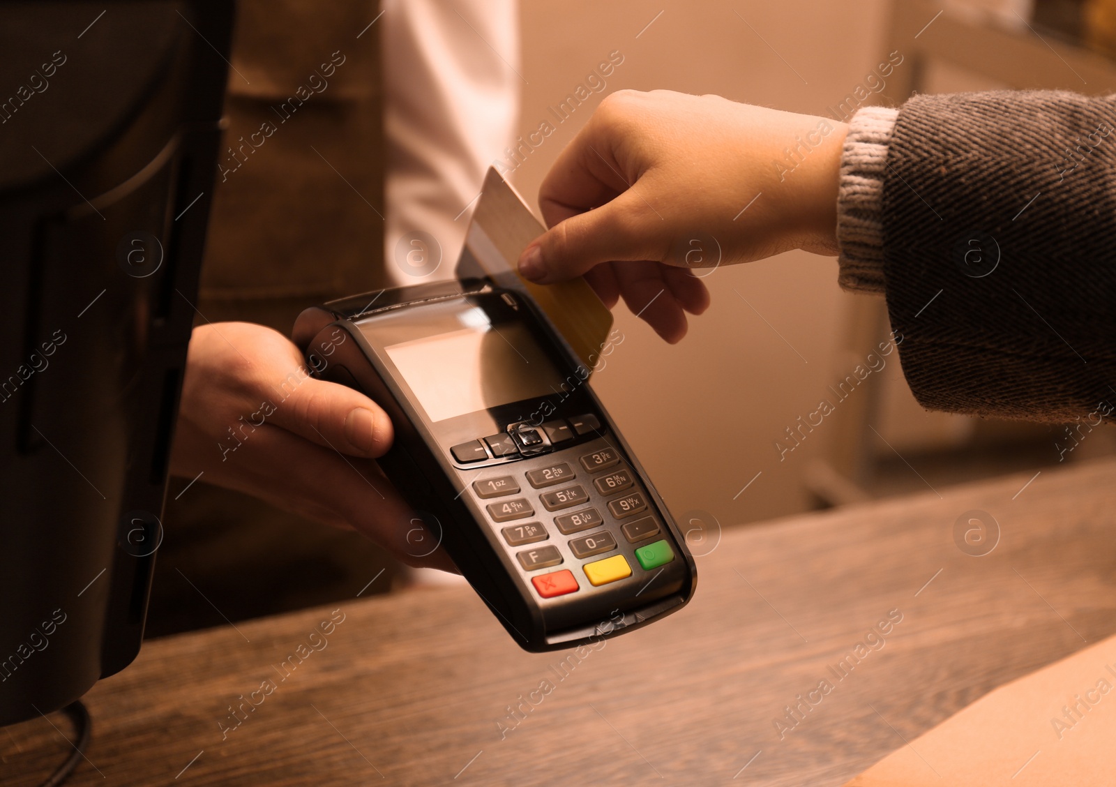 Photo of Woman with credit card using payment terminal at shop, closeup