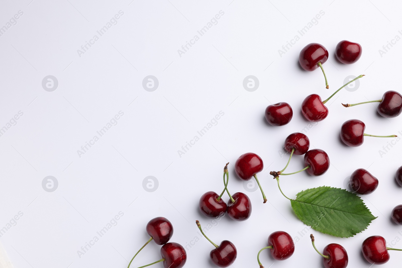 Photo of Many sweet ripe cherries on white background, flat lay. Space for text