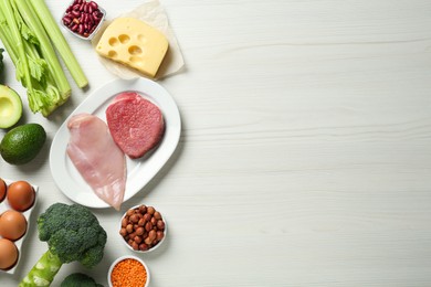 Photo of Different fresh products on white wooden table, flat lay and space for text. Sources of essential amino acids