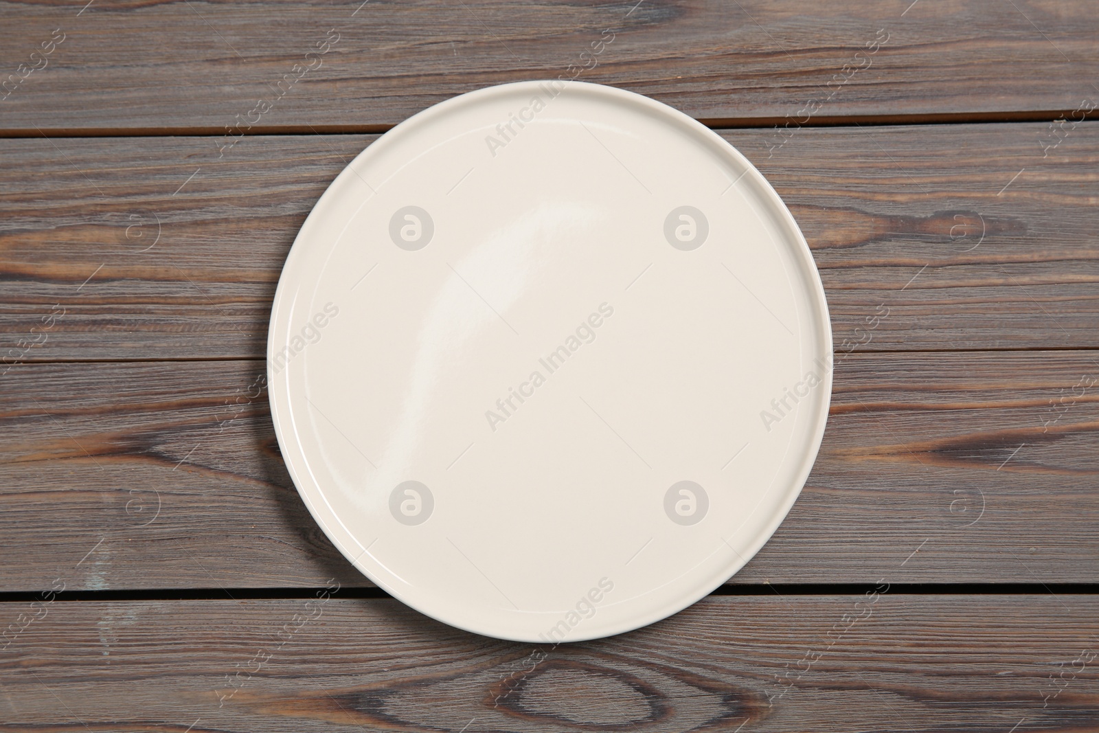 Photo of One ceramic plate on grey wooden table, top view