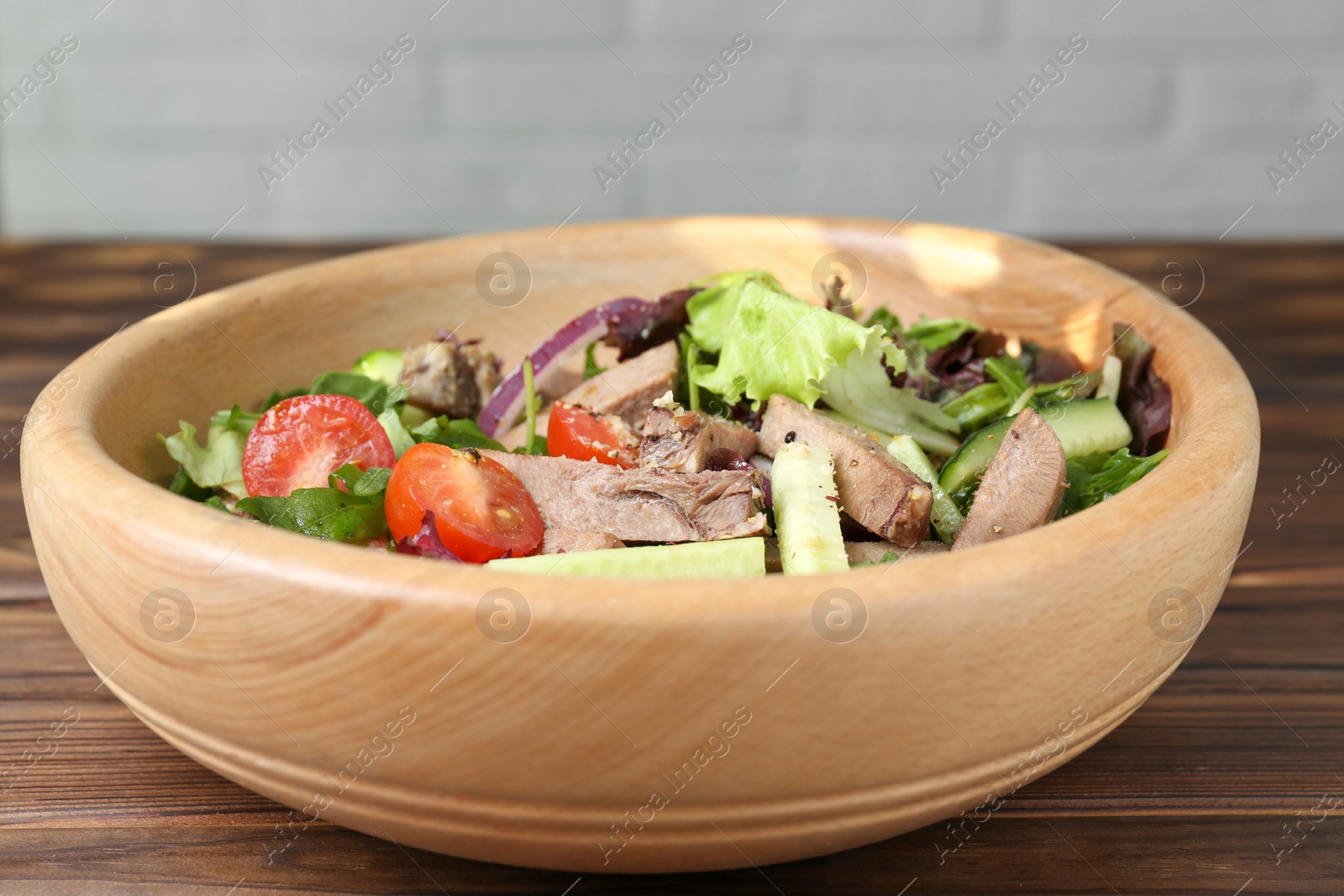 Photo of Delicious salad with beef tongue and vegetables on wooden table, closeup