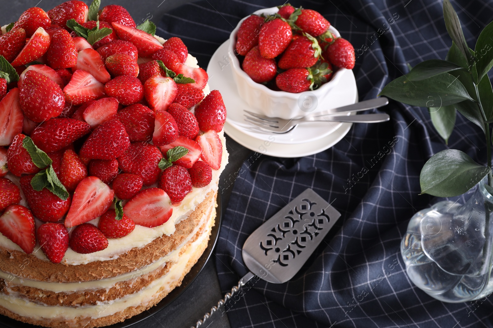 Photo of Tasty cake with fresh strawberries and mint served on table