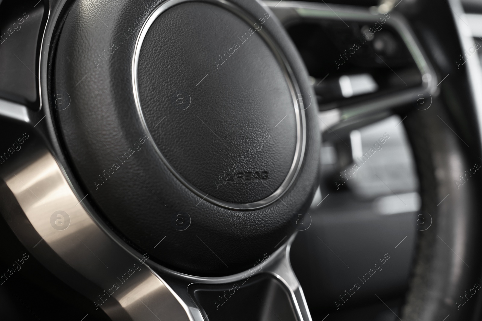 Photo of Steering wheel inside of black modern car, closeup