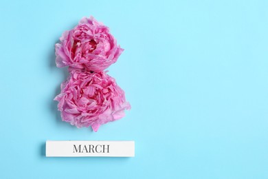 Photo of International Women's day. 8th of March made with beautiful peonies on light blue background, top view. Space for text