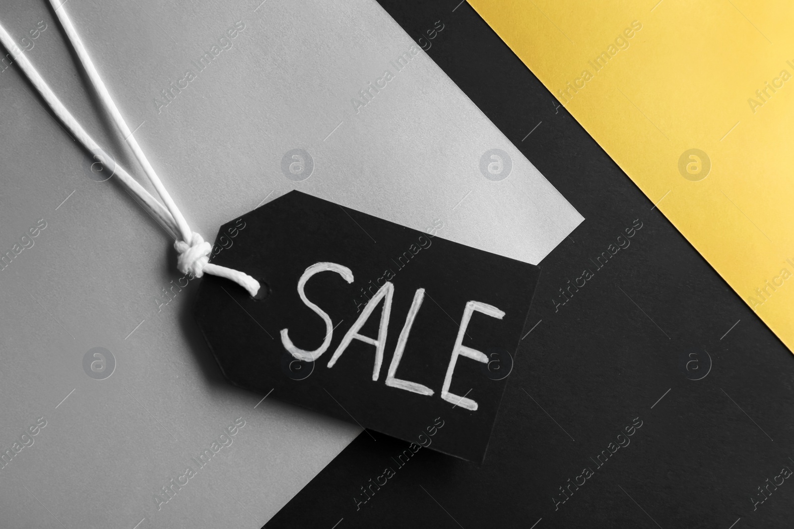 Photo of Tag with word SALE on color background, top view. Black Friday concept