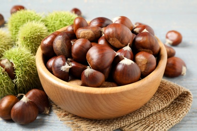 Photo of Fresh sweet edible chestnuts in bowl on table