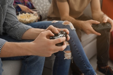 Photo of Group of friends playing video games at home, closeup