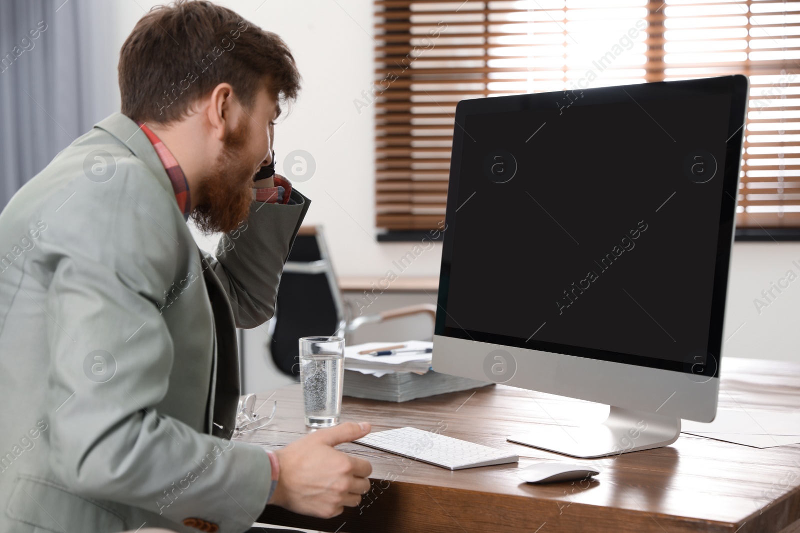 Photo of Man using video chat on computer in home office. Space for text