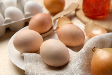 Photo of Easter eggs painted with natural dye and onion on table, closeup