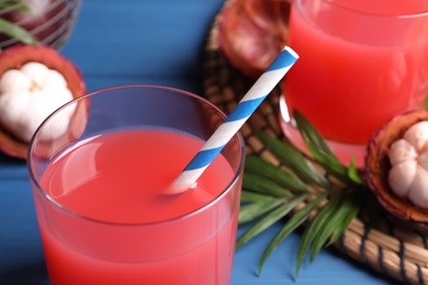 Delicious mangosteen juice in glass on table, closeup