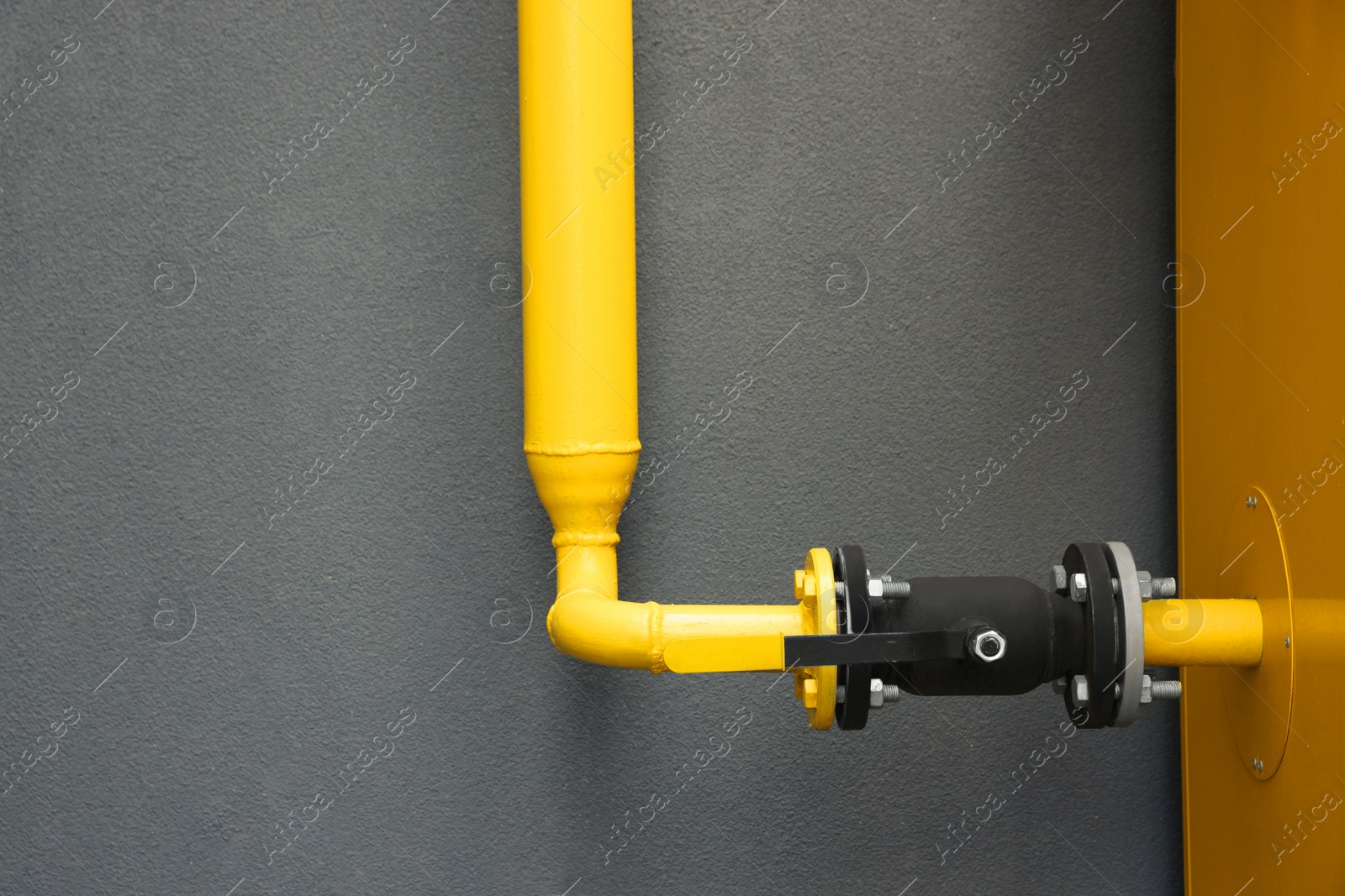 Photo of Yellow gas pipe near brown wall outdoors