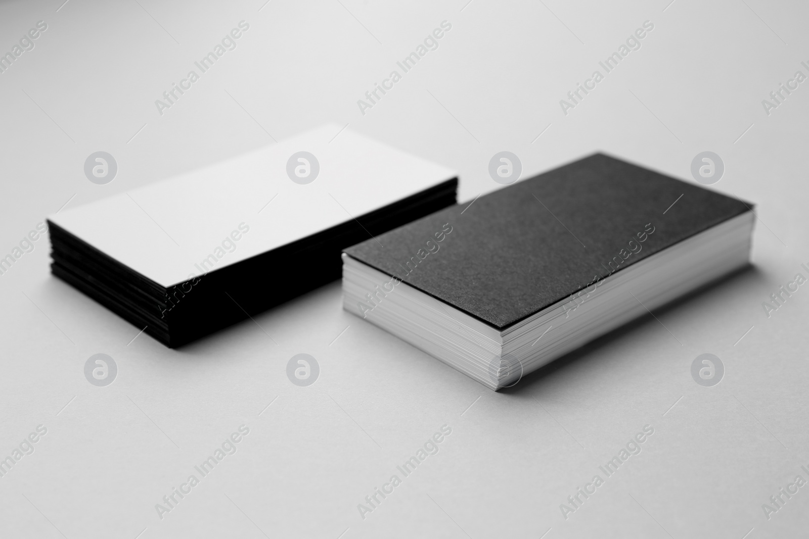 Photo of Blank black and white business cards on light background. Mockup for design